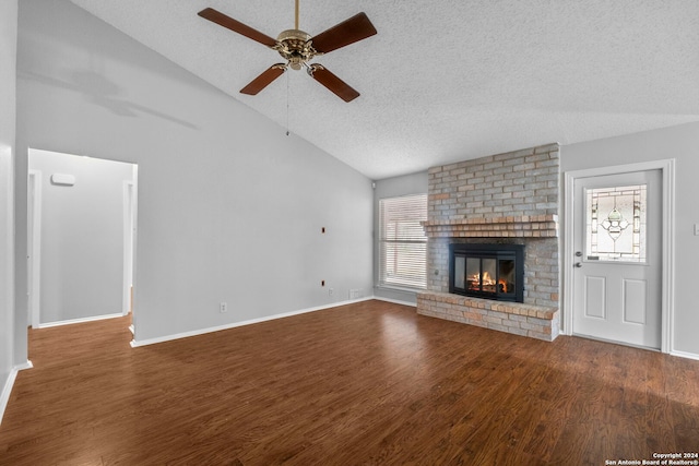 unfurnished living room with wood-type flooring, a textured ceiling, vaulted ceiling, and a wealth of natural light