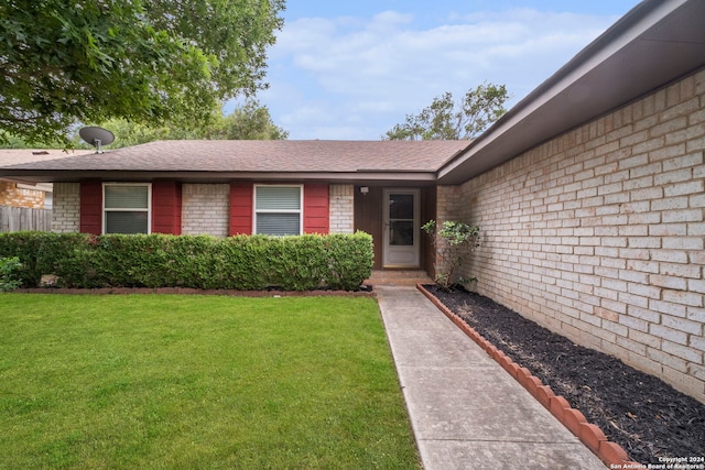 entrance to property featuring a lawn