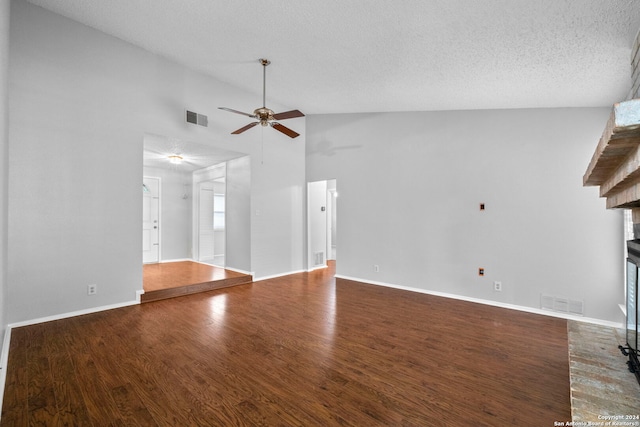 unfurnished living room featuring a fireplace, hardwood / wood-style floors, high vaulted ceiling, and a textured ceiling