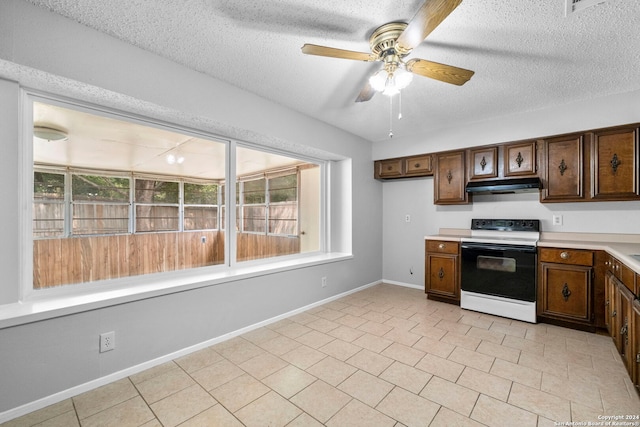 kitchen with a textured ceiling, electric range, light tile patterned floors, and ceiling fan