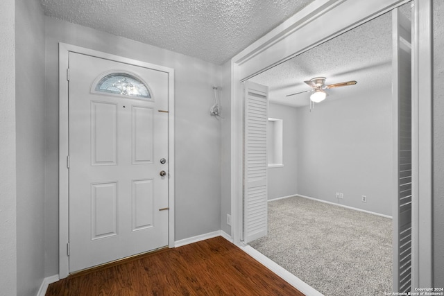 foyer entrance featuring a textured ceiling, dark hardwood / wood-style flooring, and ceiling fan