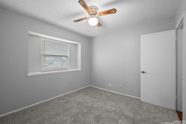 carpeted spare room with a textured ceiling and ceiling fan