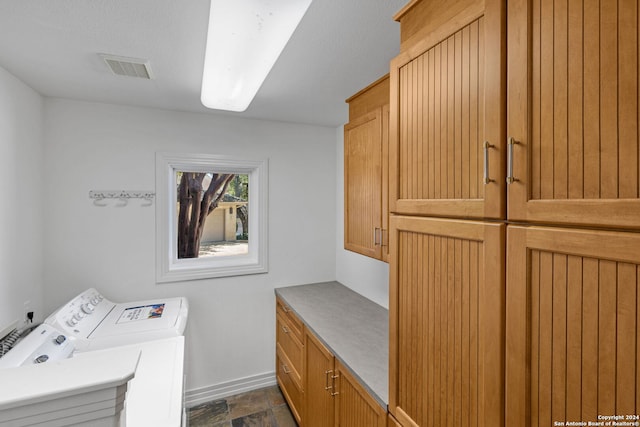 clothes washing area featuring cabinets and washing machine and dryer