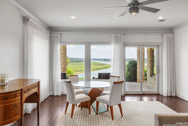 dining space with ornamental molding, ceiling fan, and dark wood-type flooring