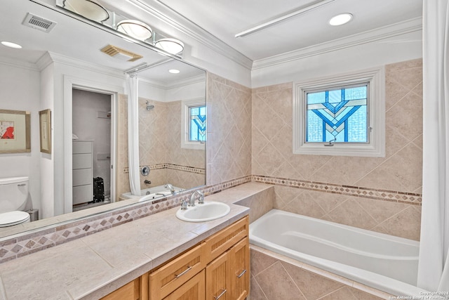 bathroom featuring vanity, ornamental molding, a wealth of natural light, and tiled bath