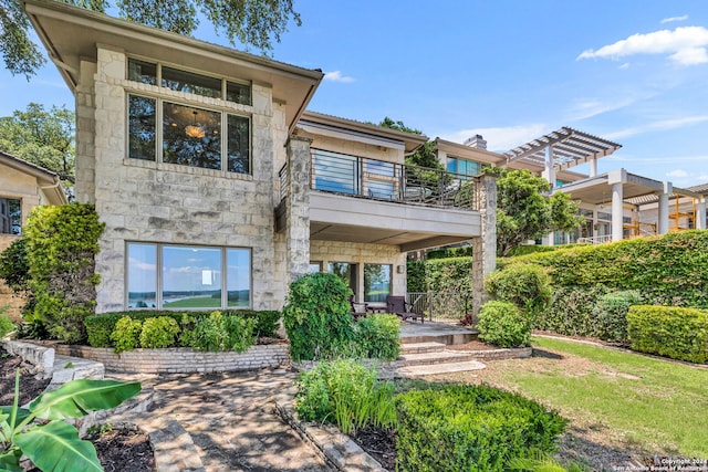 back of property featuring a pergola and a balcony