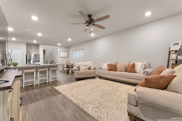 living room featuring ceiling fan and dark hardwood / wood-style floors