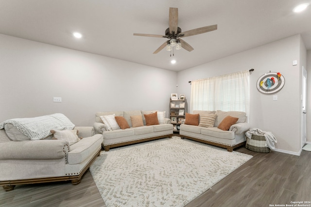 living room with dark wood-type flooring and ceiling fan