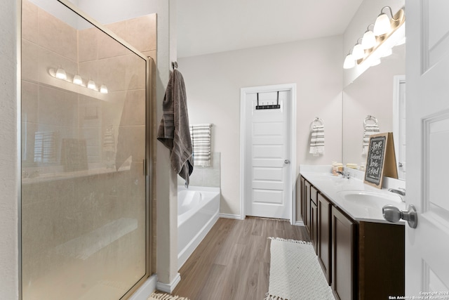 bathroom with plus walk in shower, hardwood / wood-style flooring, and dual bowl vanity