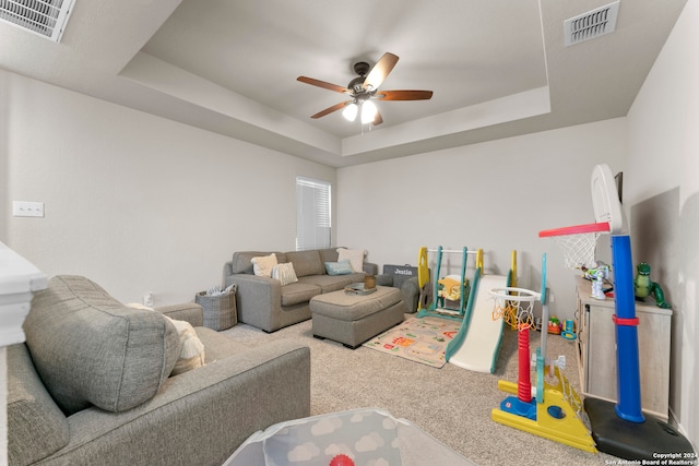 carpeted living room featuring ceiling fan and a raised ceiling