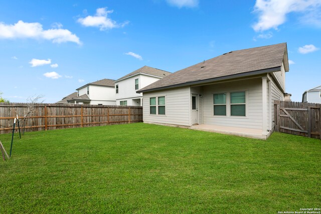 rear view of property featuring a patio and a yard