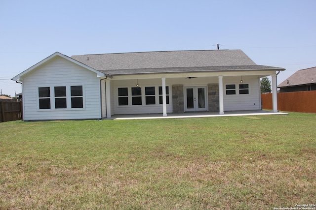 rear view of house featuring ceiling fan, a patio area, a yard, and french doors