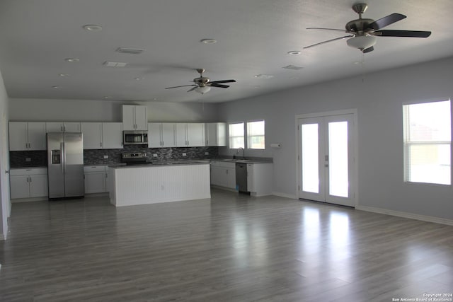 kitchen with sink, dark wood-type flooring, stainless steel appliances, decorative backsplash, and white cabinets