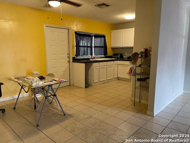 kitchen featuring white cabinetry, ceiling fan, and light tile patterned flooring