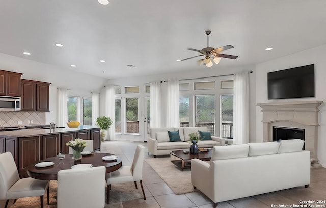 living area featuring recessed lighting, a glass covered fireplace, ceiling fan, and light tile patterned floors