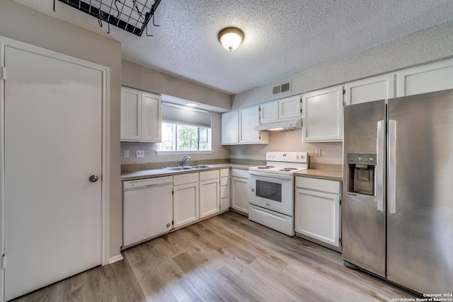 kitchen with white cabinets, light wood-type flooring, sink, and white appliances