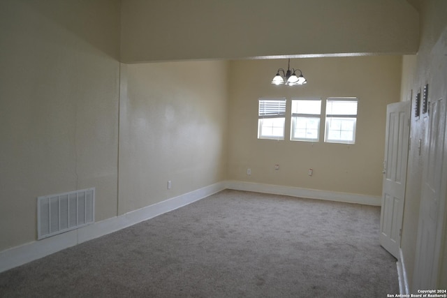 unfurnished room with light carpet and a chandelier