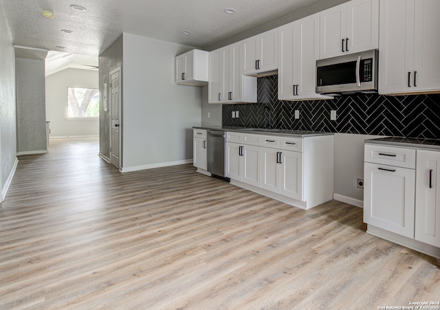 kitchen featuring appliances with stainless steel finishes, white cabinetry, and light wood-type flooring