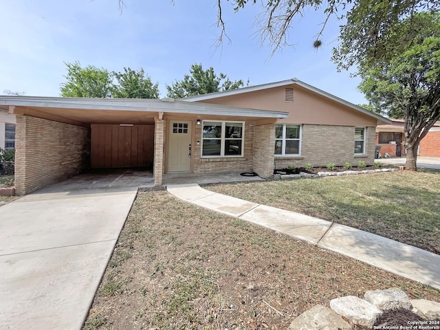 single story home featuring a front lawn and a carport