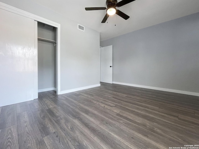 unfurnished bedroom with ceiling fan, dark hardwood / wood-style flooring, and a closet