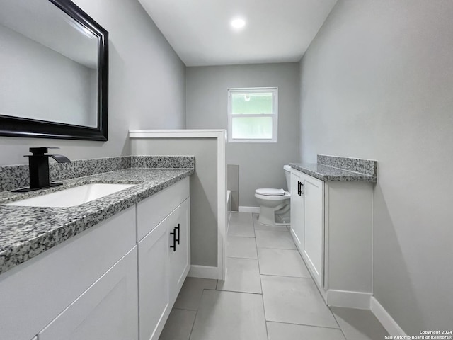 bathroom with tile patterned flooring, vanity, and toilet