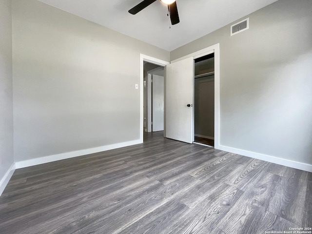 unfurnished bedroom featuring ceiling fan, dark hardwood / wood-style floors, and a closet