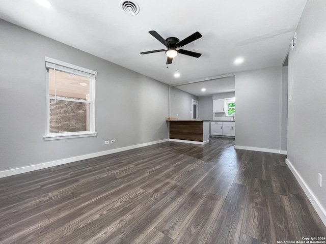 unfurnished living room with ceiling fan and dark hardwood / wood-style floors