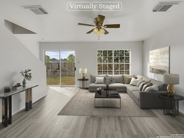 living room featuring ceiling fan and light hardwood / wood-style floors