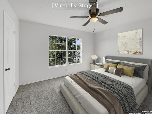 carpeted bedroom with ceiling fan and a textured ceiling