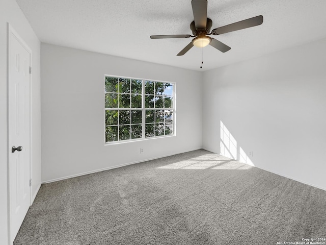 carpeted spare room with ceiling fan and a textured ceiling