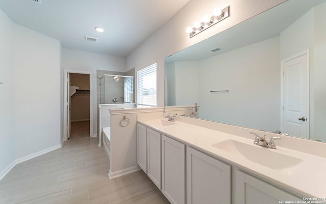 full bathroom featuring a garden tub, a spacious closet, visible vents, and a sink