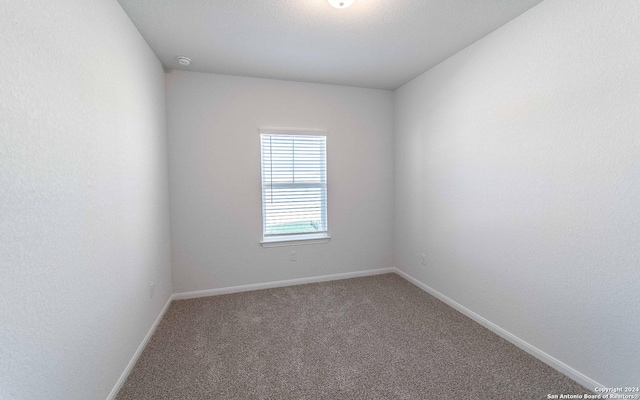 empty room with carpet and baseboards