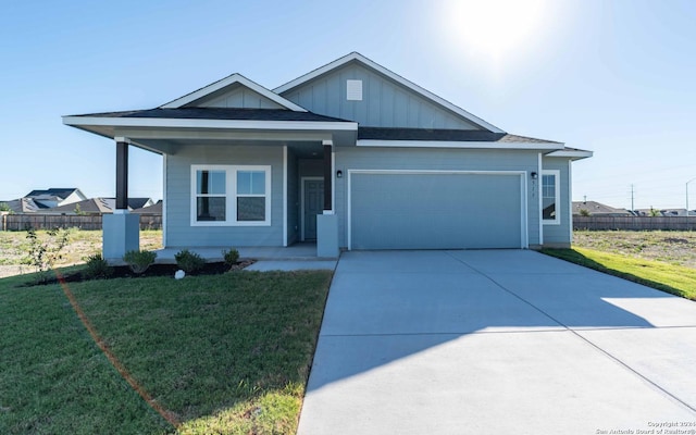 view of front of house featuring an attached garage, concrete driveway, a front lawn, and fence