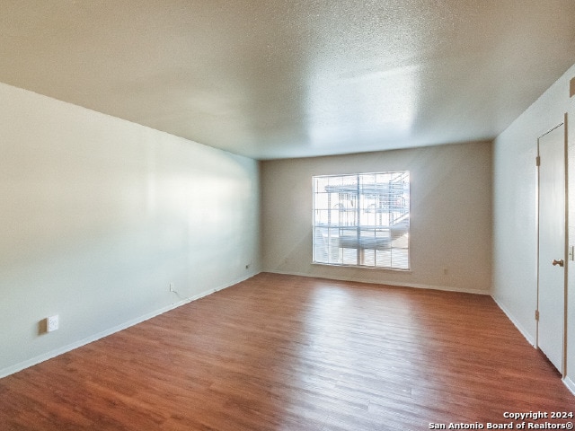 spare room with wood-type flooring and a textured ceiling