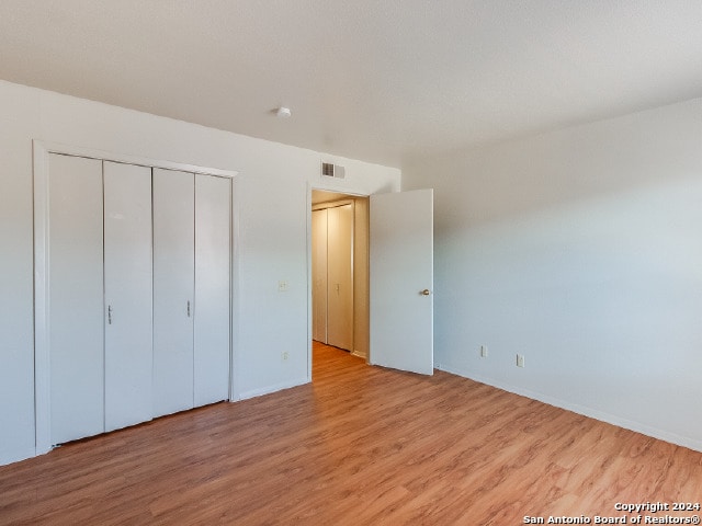 unfurnished bedroom with a closet and light hardwood / wood-style flooring