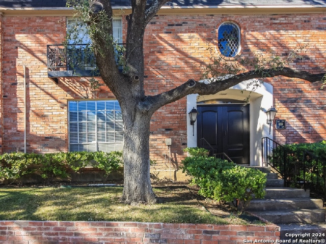 view of exterior entry with a yard