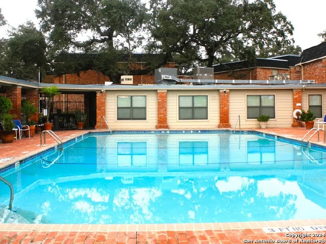 view of pool with a patio and central AC unit