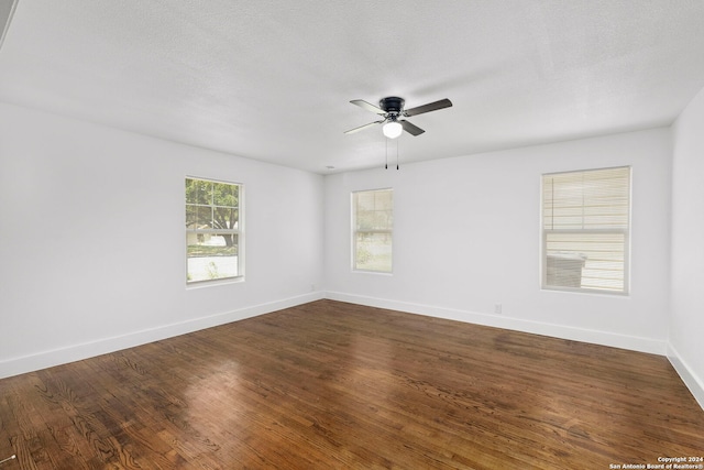 empty room featuring dark hardwood / wood-style floors, ceiling fan, and a textured ceiling