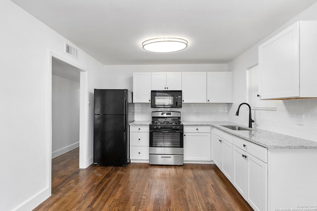 kitchen with sink, dark hardwood / wood-style floors, white cabinetry, and black appliances