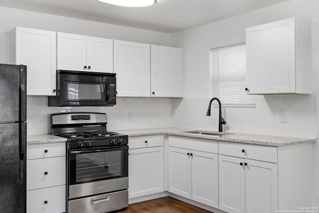 kitchen featuring white cabinetry, sink, light stone counters, backsplash, and black appliances