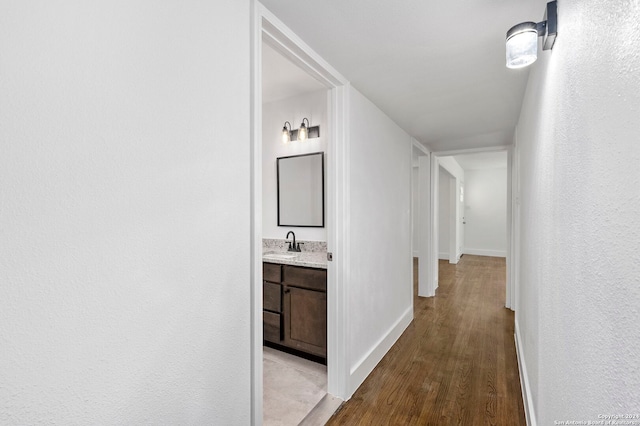 corridor featuring light hardwood / wood-style flooring and sink