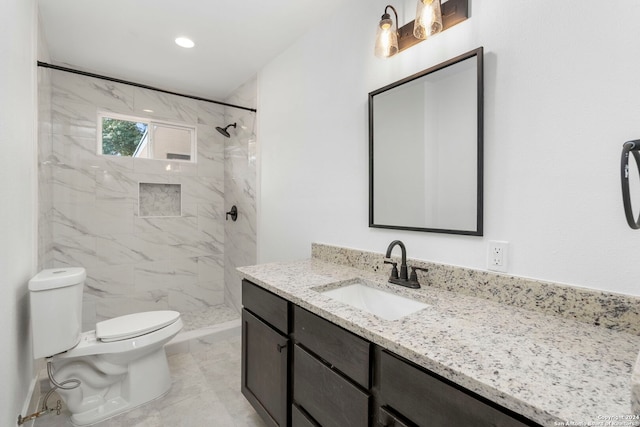 bathroom featuring vanity, toilet, and tiled shower