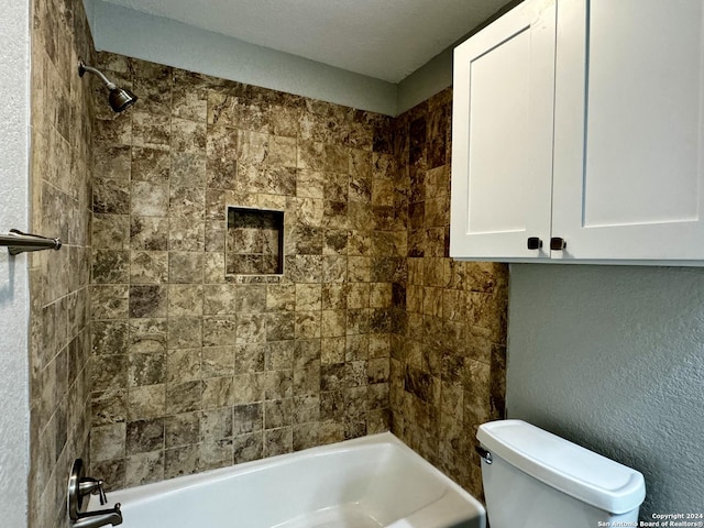 bathroom with tiled shower / bath combo and toilet