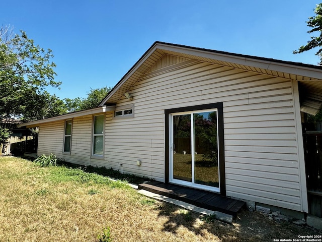 view of side of home with a yard