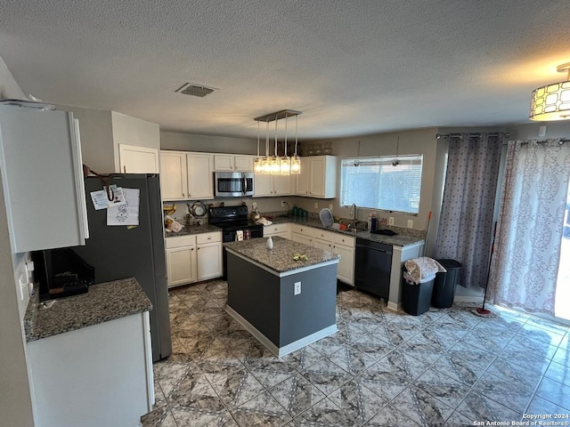 kitchen featuring white cabinets, a textured ceiling, a center island, and black appliances