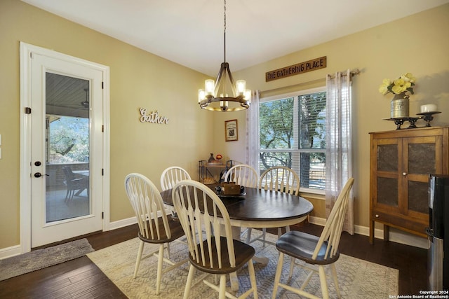 dining room with dark hardwood / wood-style floors, a healthy amount of sunlight, and a chandelier