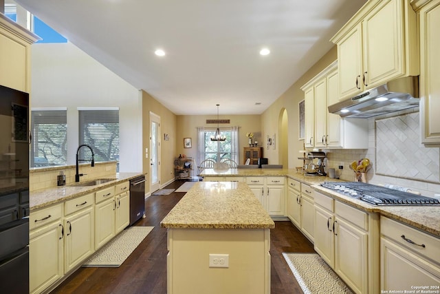 kitchen with cream cabinetry, kitchen peninsula, hanging light fixtures, and stainless steel gas cooktop