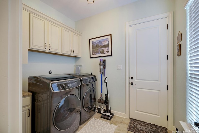 clothes washing area with cabinets, light tile patterned floors, and independent washer and dryer