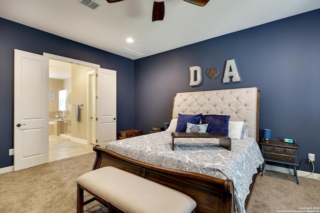 carpeted bedroom with ensuite bath and ceiling fan