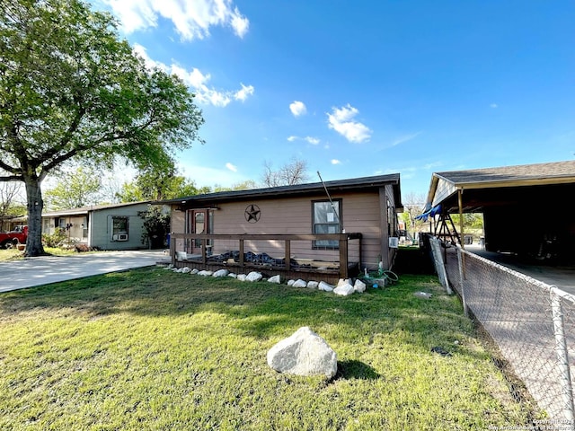 manufactured / mobile home with a front lawn and a carport